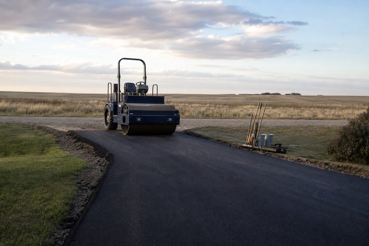 Asphalt paving crew rolling a new driveway in Saskatoon